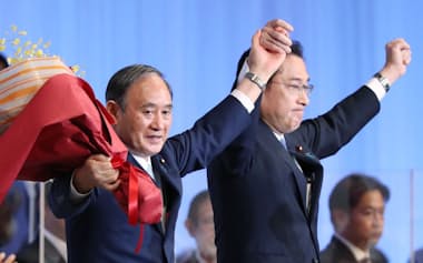 自民党の新総裁に選出され、菅首相と並んで拍手に応える岸田文雄氏（29日、東京都港区）
