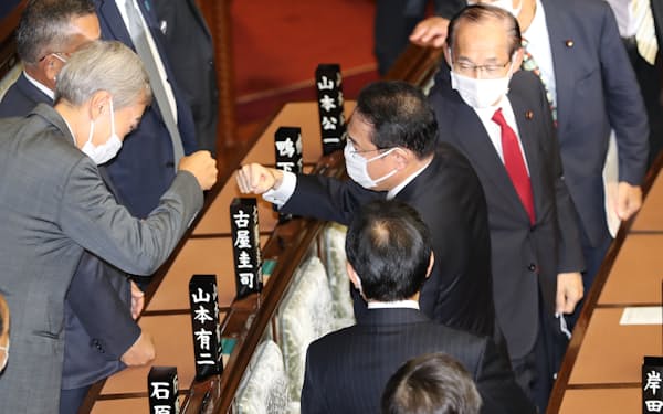 衆院本会議で首相に選出され、石原伸晃氏と拳を合わせる自民党の岸田文雄総裁(4日)