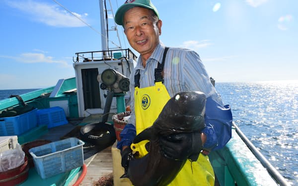 ヨロイザメを抱える長谷川久志さん