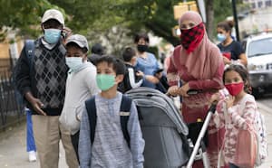 新型コロナ感染対策のためマスクを着けて登校する子どもと付き添いの保護者(ニューヨーク市、9月)=AP 新型コロナ感染対策のためマスクを着けて登校する子どもと付き添いの保護者(ニューヨーク市、9月)=AP