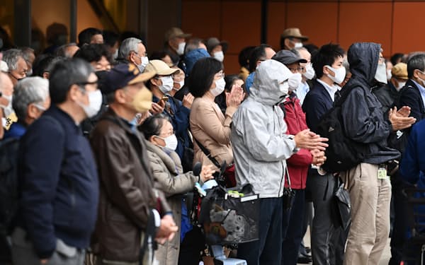 衆院選が公示され、候補者らの街頭演説を聞く有権者（19日午前、東京都新宿区）