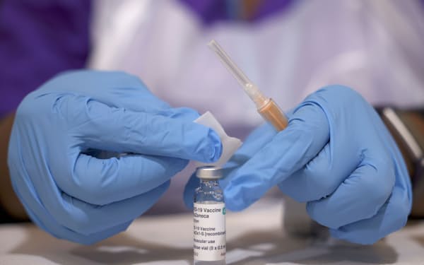 3月、ロンドンのワクチン接種センターで接種の準備作業をする医療関係者＝ロイター