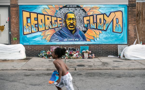 ミネアポリスにあるジョージ・フロイドを描いた壁画の前を少年が走る（2021年5月）＝The New York Times/Redux/アフロ