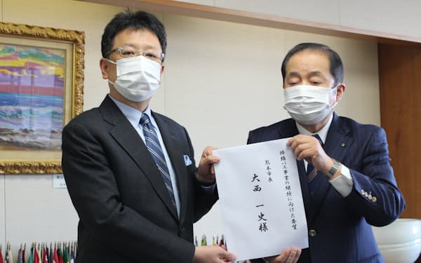 バス５社への支援を求める要望書を熊本市の大西市長㊧に手渡した熊本電気鉄道の中島敬高社長（25日、熊本市）