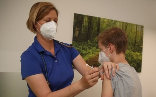 新型コロナウイルス感染症のワクチンを男児に接種する小児科医。ドイツ、ノルトライン・ベストファーレン州で6月9日に撮影。（PHOTOGRAPH BY DAVID YOUNG, PICTURE ALLIANCE VIA GETTY）