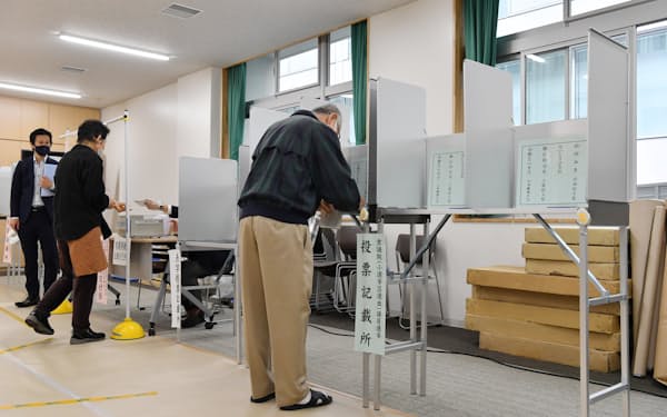 投票用紙に記入する有権者(31日、東京都千代田区)