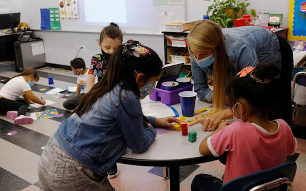 Teacher Emma Rossi works with her first grade students at the Sokolowski School, where students and teachers are required to wear masks because of the coronavirus disease (COVID-19) pandemic, in Chelsea, Massachusetts, U.S., September 15, 2021.   REUTERS/Brian Snyder