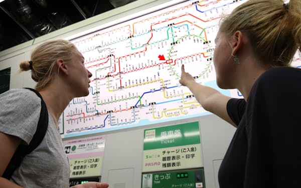 駅の路線図を見る外国人観光客（東京都新宿区、2015年7月）