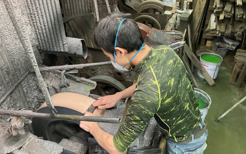 先輩職人が鍛えた包丁を研ぎ上げる小林さん(堺市の富樫打刃物製作所で) 先輩職人が鍛えた包丁を研ぎ上げる小林さん(堺市の富樫打刃物製作所で)