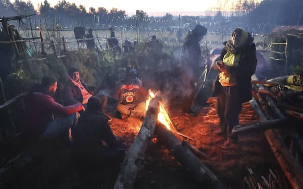 厳しい寒さに見舞われ、たき火で暖をとる移民（10日、ポーランド国境に近いベラルーシ西部グロドノ付近）＝ＡＰ