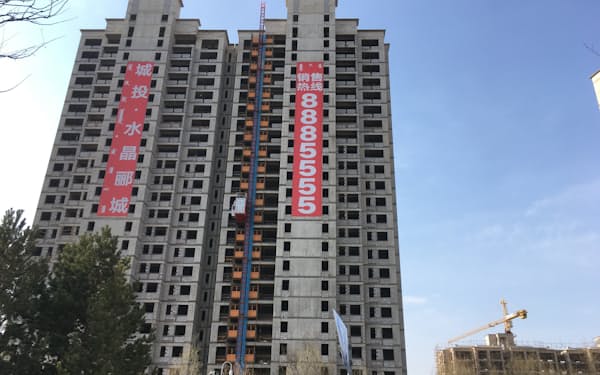 販売中を知らせる垂れ幕をかけた新築物件（4月、内モンゴル自治区オルドス市）