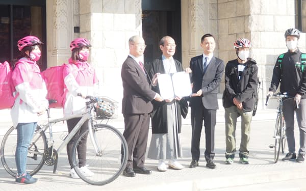 料理宅配の業界団体と交通安全に関わる連携協定を結んだ京都市の門川大作市長（写真中央）ら