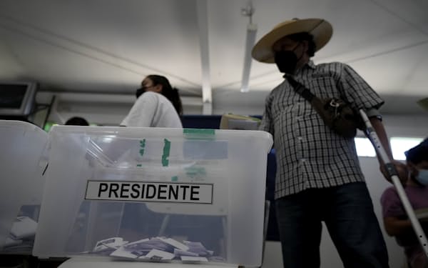 21日、首都サンティアゴの投票所を訪れた市民=AP