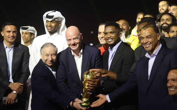 Ｗ杯カタール大会開幕１年前イベントで優勝トロフィーを見せるカフー（ブラジル）、エトー（カメルーン）、FIFAのインファンティノ会長ら（右から）＝ロイター