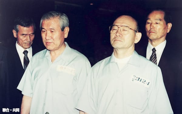 1996年、79年の粛軍クーデターや80年の光州事件の反乱・内乱罪に問われ法廷に立つ韓国の盧泰愚元大統領(手前左)と全斗煥元大統領(同右)=聯合・共同