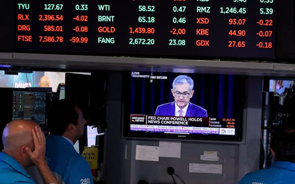 FILE PHOTO: Traders look on as a screen shows Federal Reserve Chairman Jerome Powell's news conference after the U.S. Federal Reserve interest rates announcement on the floor of the New York Stock Exchange (NYSE) in New York, U.S., July 31, 2019. REUTERS/Brendan McDermid/File Photo