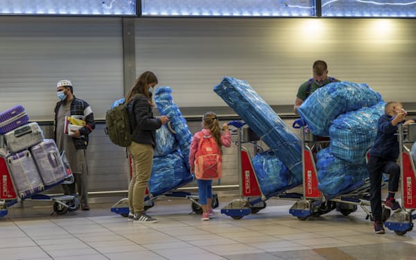 南アフリカのヨハネスブルクの空港で、国際線に搭乗するために列をつくる人々（26日）=AP