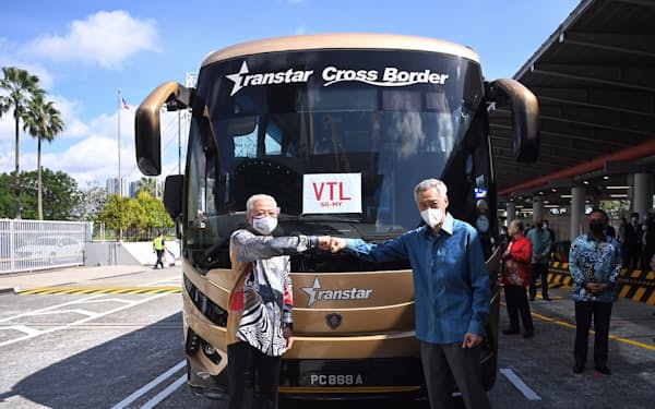陸路での隔離なし入国再開に立ち会うシンガポールのリー・シェンロン首相（右）とマレーシアのイスマイルサブリ首相（29日）＝マレーシア政府提供