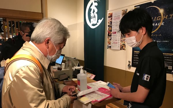 飲食店員によるワクチン接種証明の確認風景（札幌市内）