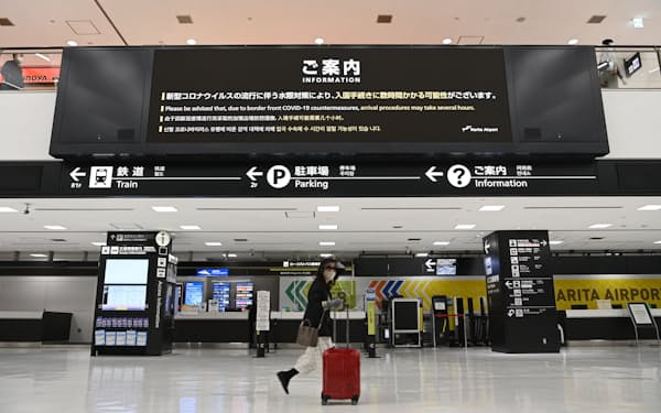 国際線到着ロビーのモニターに表示された新型コロナウイルスの水際対策についての案内（28日、成田空港）
