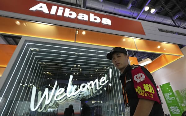 FILE - A security guard passes by the Alibaba booth at a trade show in Beijing, China, Tuesday, Sept. 7, 2021. Chinese tech giants including Alibaba Group and Tencent Holdings were fined Saturday, Nov. 20, for failing to report corporate acquisitions, adding to an anti-monopoly crackdown by the ruling Communist Party. (AP Photo/Ng Han Guan, File)