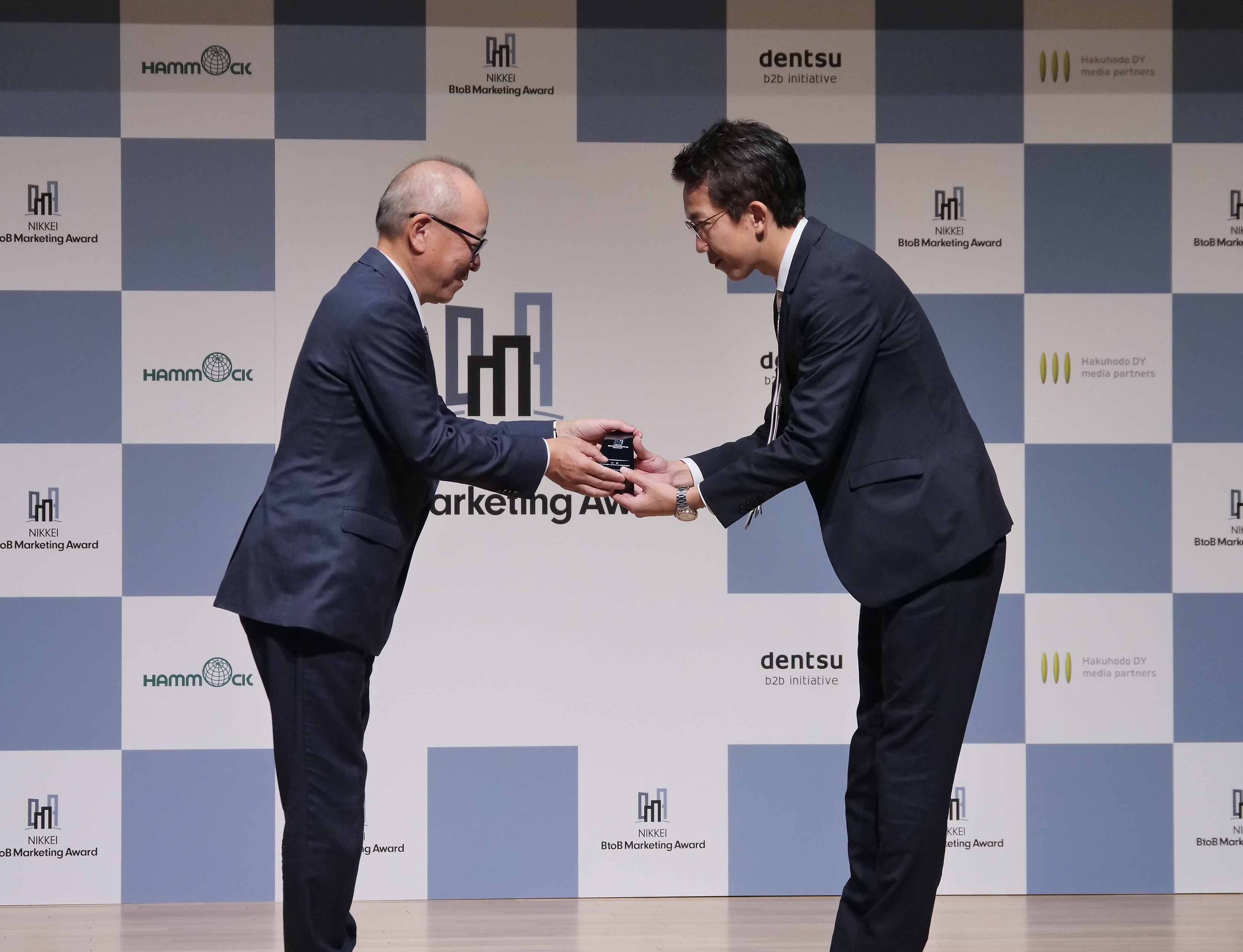 日本経済新聞社の渡辺洋之専務（左）から大賞を受賞したパーソルホールディングスの繁田佳典氏にトロフィーが贈られた。