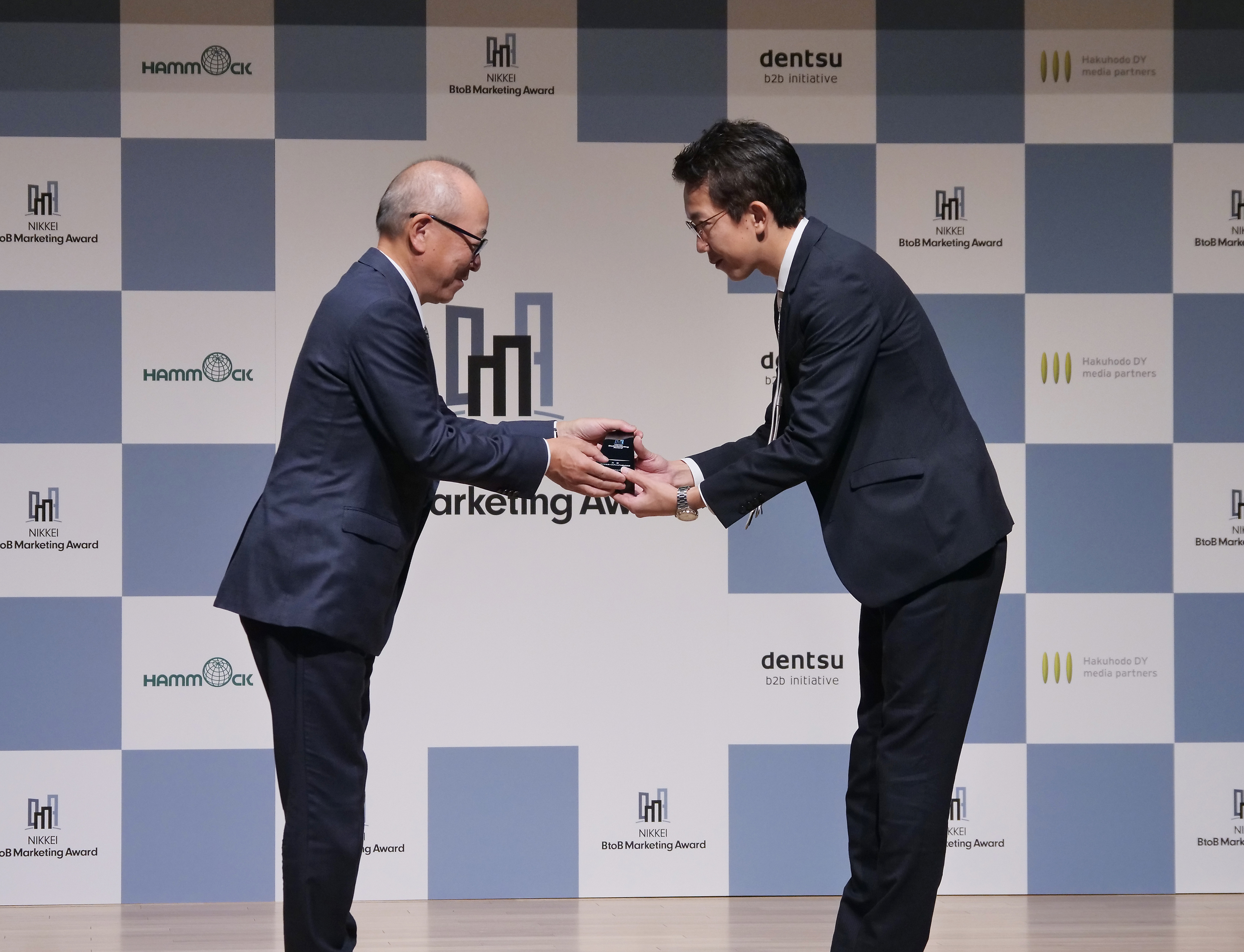 日本経済新聞社の渡辺洋之専務(左)から大賞を受賞したパーソルホールディングスの繁田佳典氏にトロフィーが贈られた。