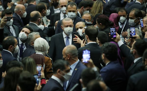 11月23日、アンカラで与党議員に囲まれるエルドアン大統領(中央)=ロイター