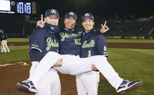 日本一に輝き、村上㊧と山田に担がれて笑顔の高津監督=共同 日本一に輝き、村上㊧と山田に担がれて笑顔の高津監督=共同