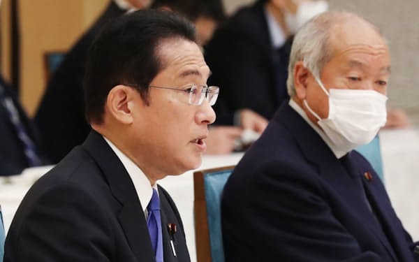 政府・与党連絡会議であいさつする岸田首相。右は鈴木財務相（29日、首相官邸）