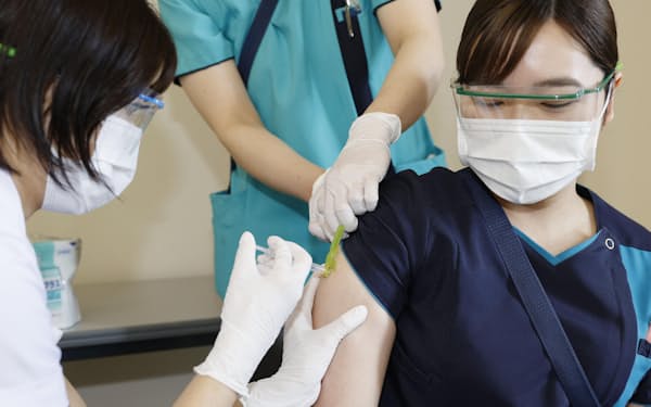 新型コロナウイルスワクチンの追加接種を受ける看護師＝共同