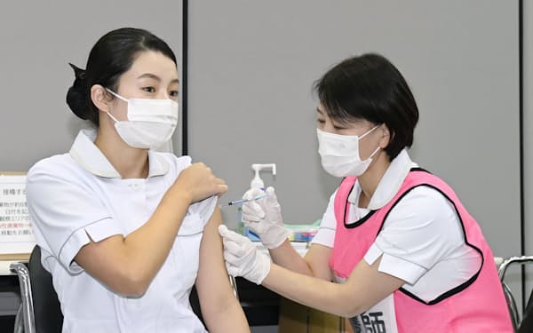 　新型コロナウイルスワクチンの3回目の追加接種を受ける看護師（左）＝1日午前、愛知県豊明市の藤田医大病院