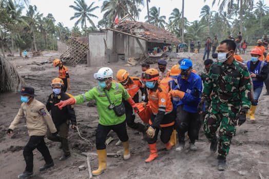 6日、スメル山噴火による犠牲者を搬送する救助隊（インドネシア・ジャワ島東部）=ゲッティ共同