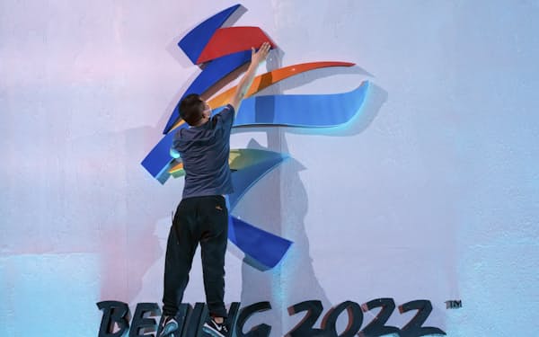 北京冬季五輪のロゴを固定する作業をしている人（9月17日）=AP
