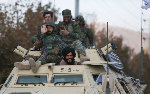 カブールでの軍事パレードで、装甲車に乗るタリバンの戦闘員ら（11月14日）＝ロイター