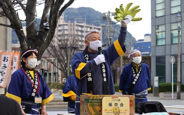 門司港バナナの叩き売り連合会のメンバーが実演会を開いている（北九州市）