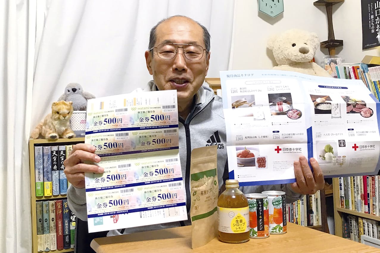 ワタミの食事券（左）と飯野海運の優待カタログを持つ桐谷さん