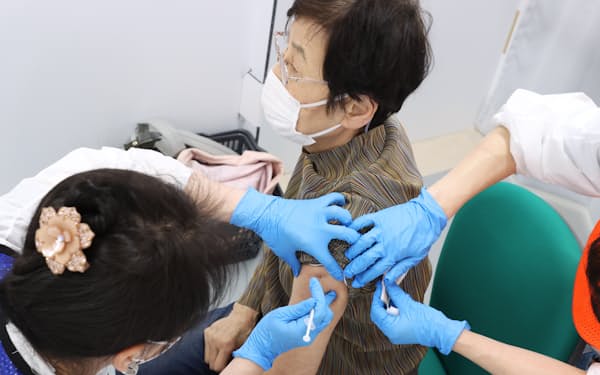 集団接種会場でワクチンの注射を受ける女性（4月、名古屋市中区）
