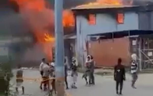 11月、中国系住民が多い地区で燃え上がる建物＝ロイター