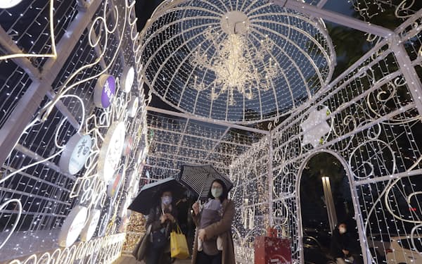 People wearing face masks to protect against the spread of the coronavirus walk past Christmas decoration in Taipei, Taiwan, Thursday, Dec. 23, 2021. (AP Photo/Chiang Ying-ying)
