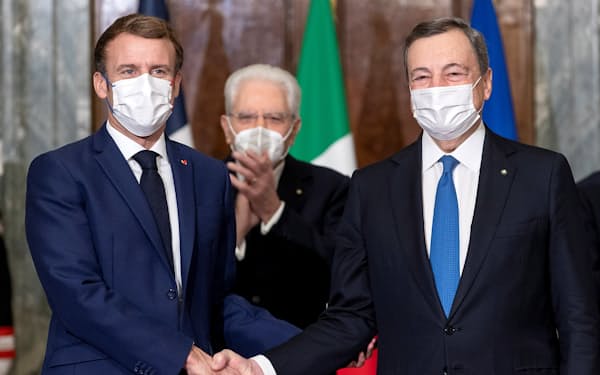 ２国間関係強化の条約に署名し、握手するフランスのマクロン大統領（左）とイタリアのドラギ首相（11月26日、ローマ）＝ロイター