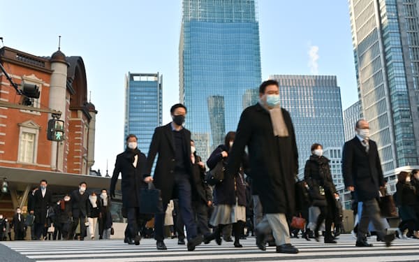 仕事始めを迎え、マスク姿で通勤する人たち(4日午前、東京・丸の内)