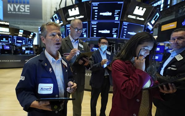 Robert Charmak, left, works with fellow traders on the floor of the New York Stock Exchange, Wednesday, July 28, 2021. Global stock markets were mixed Wednesday after Wall Street pulled back from a record as investors awaited a Federal Reserve report for signs of when U.S. stimulus might be withdrawn. (AP Photo/Richard Drew)