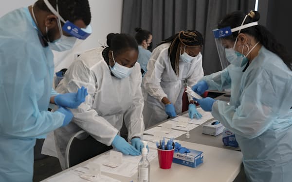 Healthcare workers Henry Paul, from left, Ray Akindele, Wilta Brutus and Leslie Powers process COVID1-9 rapid antigen tests at a testing site in Long Beach , Calif., Thursday, Jan. 6, 2022. (AP Photo/Jae C. Hong)