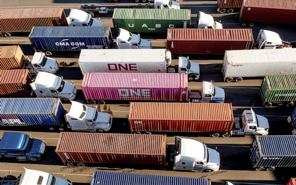 トラック運転手の不足で物流の混乱が続いている（米カリフォルニア州の港で行列をつくるトラック）=AP