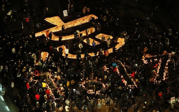 阪神大震災から27年を迎え、追悼会場に灯籠の明かりで浮かび上がった「忘　1・17」の文字（17日午前、神戸市中央区の東遊園地）