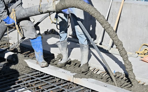 ビルの建設現場で枠に流し込まれる生コンクリート（東京都内）