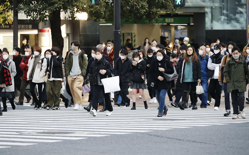 東京・渋谷のスクランブル交差点をマスク姿で横断する人たち（17日午後）=共同