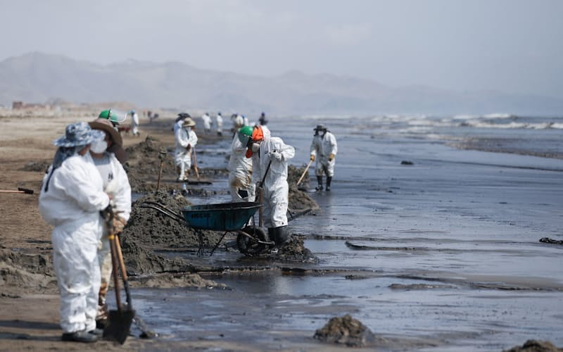 18日、ペルー首都郊外の海岸で、流出した原油を清掃する作業員=ロイター・共同