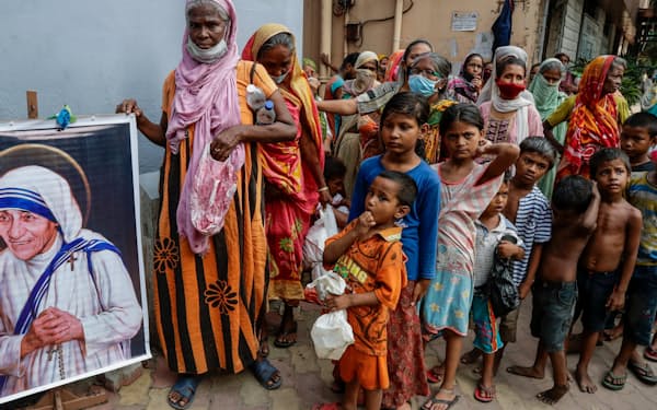 マザー・テレサの活動を受け継ぐ団体の施設で食料を受け取るホームレスら（2021年8月、インド東部コルカタ）＝ＡＰ